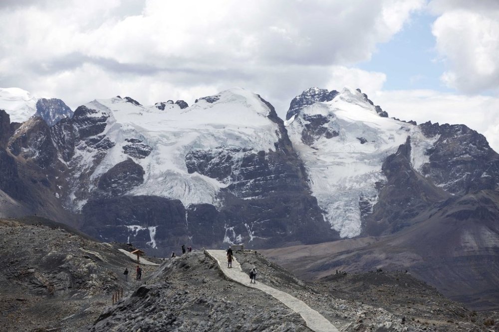 FILE - Tourists walk in front of the Tuco glacier in Huascaran National Park during a tour called the
