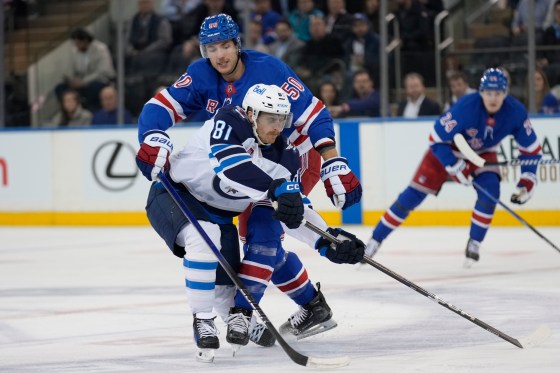 New York Rangers' Will Cuylle, top, grabs Winnipeg Jets' Kyle Connor, front, and is called for a holding penalty during the Nov. 12, 2024 game. (Seth Wenig / The Associated Press files)