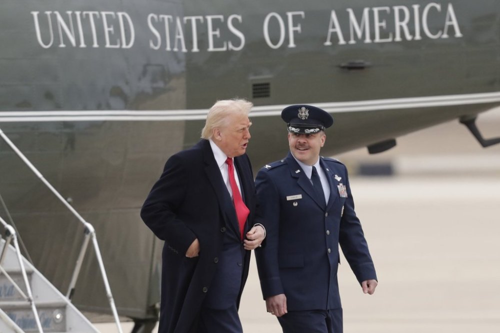 President Donald Trump is escorted by Col. Paul Pawluk, Vice Commander of the 89th Airlift Wing, right, as he walks from Marine One before boarding Air Force One, Friday, March 14, 2025, at Joint Base Andrews, Md. (AP Photo/Luis M. Alvarez)