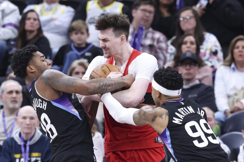 Toronto Raptors centre Colin Castleton, centre, is tied up by Utah Jazz forwards Brice Sensabaugh (28) and KJ Martin (99) during first half NBA basketball action in Salt Lake City, Friday, March 14, 2025. THE CANADIAN PRESS/AP-Rob Gray