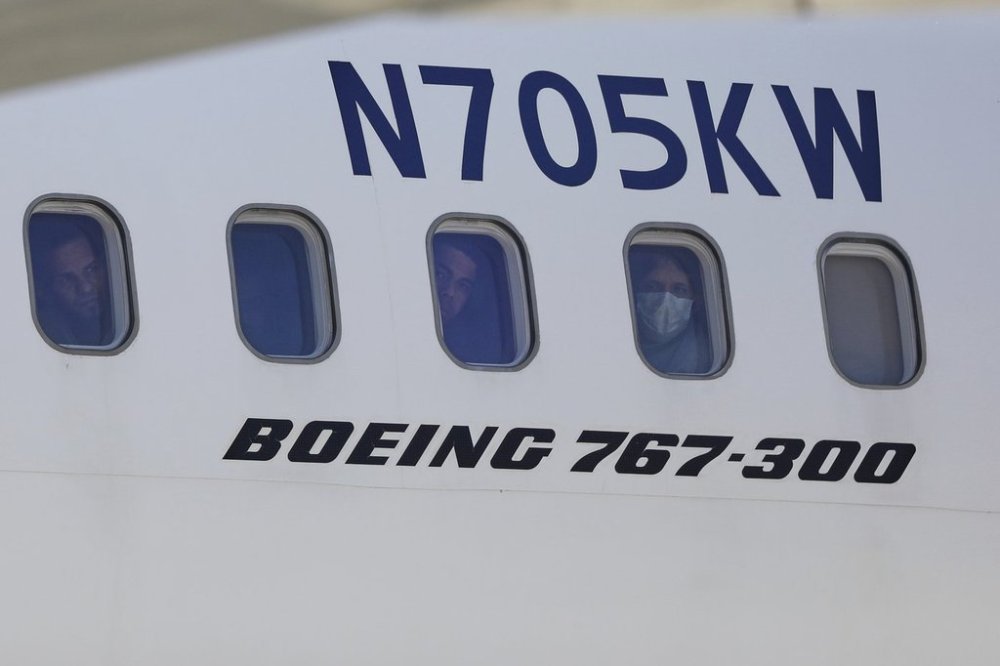 Venezuelan migrants deported from the United States peer through windows of an Eastern Airlines plane upon arriving at Simon Bolivar International Airport in Maiquetia, Venezuela, Sunday, March 30, 2025. (AP Photo/Cristian Hernandez)