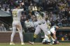 Athletics' Brent Rooker (25) celebrates with Shea Langeliers (23) at home plate after they scored on Langeliers' two-run home run as Seattle Mariners catcher Cal Raleigh, right, looks on during the fourth inning of a baseball game, Saturday, March 29, 2025, in Seattle. (AP Photo/Jason Redmond)