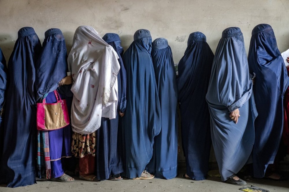 FILE - Afghan women wait to receive food rations distributed by a humanitarian aid group, in Kabul, Afghanistan, May 23, 2023. (AP Photo/Ebrahim Noroozi, File)