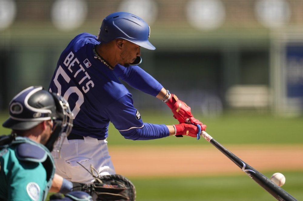 Los Angeles Dodgers' Mookie Betts singles during the first inning during a spring training baseball game against the Seattle Mariners, Tuesday, Feb. 25, 2025, in Phoenix. (AP Photo/Ashley Landis)
