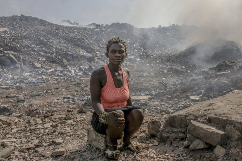 Zainab Sakoteh sits in the Kingtom landfill in Freetown, Sierra Leone, Thursday, March 13, 2025, a place she frequents to meet the cartel that provide her with Kush. (AP Photo/Caitlin Kelly)