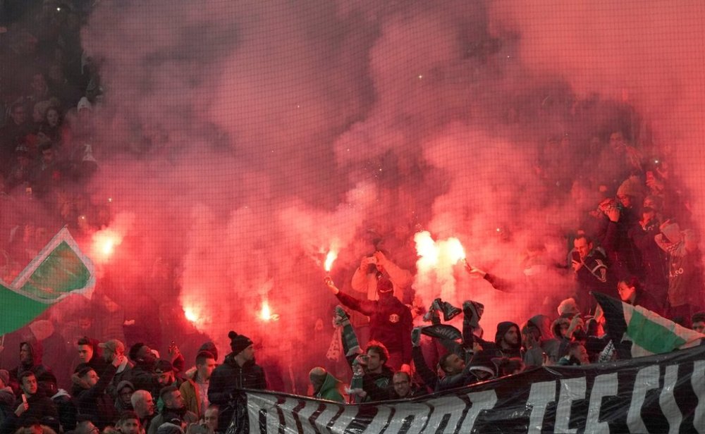 FILE - Saint-Etienne's fans light flares before the French League One soccer match between Saint-Etienne and Paris Saint-Germain, at the Geoffroy Guichard stadium, in Saint-Etienne, central France, on Dec. 15, 2019. (AP Photo/Laurent Cipriani)