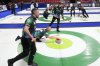 Canada's Brad Jacobs throws a stone as Ben Hebert and Brett Gallant, third from left wearing long sleeves, prepare to sweep during World Men's Curling Championship action against Italy, in Moose Jaw, Sask., Tuesday, April 1, 2025. THE CANADIAN PRESS/Chris Young