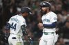 Seattle Mariners' J.P. Crawford, right, reacts to scoring on a sacrifice fly from Victor Robles while being greeted by teammate Julio Rodriguez, left, during the seventh inning of an opening-day baseball game against the Athletics, Thursday, March 27, 2025, in Seattle. (AP Photo/Lindsey Wasson)