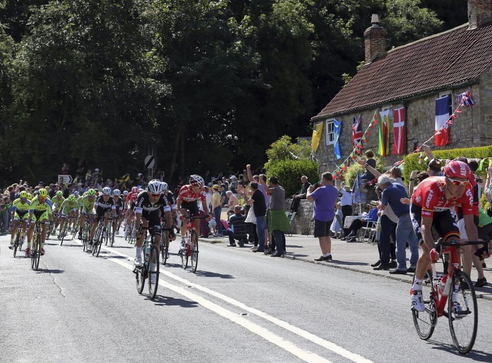 FILE - Tour De France riders cycle through the village of West Tanfield, England during the first stage of the race Saturday, July 5, 2014.. (AP Photo/Scott Heppell, File)