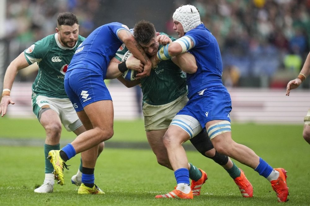 Ireland's Dan Sheehan, center, is tackled by Italy's Gianmarco lucchesi, left, and Manuel Zuliani during the Six Nations rugby match between Italy and Ireland, at Rome's Olympic Stadium, Saturday, March 15, 2025. (AP Photo/Andrew Medichini)