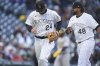 Colorado Rockies starting pitcher Germán Márquez, right, congratulates third baseman Ryan McMahon after he fielded a ground ball off the bat of the Athletics' Jacob Wilson to initiate a triple play to end the top of the second inning of a baseball game Saturday, April 5, 2025, in Denver. (AP Photo/David Zalubowski)