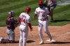 Los Angeles Angels' Jorge Soler, right, is congratulated by Logan O'Hoppe, center, after hitting a solo home run as Cleveland Guardians catcher Austin Hedges kneels at the plate during the sixth inning of a baseball game Sunday, April 6, 2025, in Anaheim, Calif. (AP Photo/Mark J. Terrill)