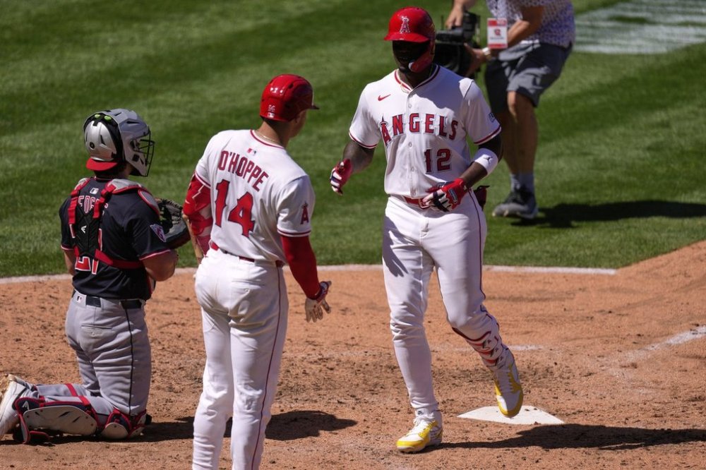 Los Angeles Angels' Jorge Soler, right, is congratulated by Logan O'Hoppe, center, after hitting a solo home run as Cleveland Guardians catcher Austin Hedges kneels at the plate during the sixth inning of a baseball game Sunday, April 6, 2025, in Anaheim, Calif. (AP Photo/Mark J. Terrill)