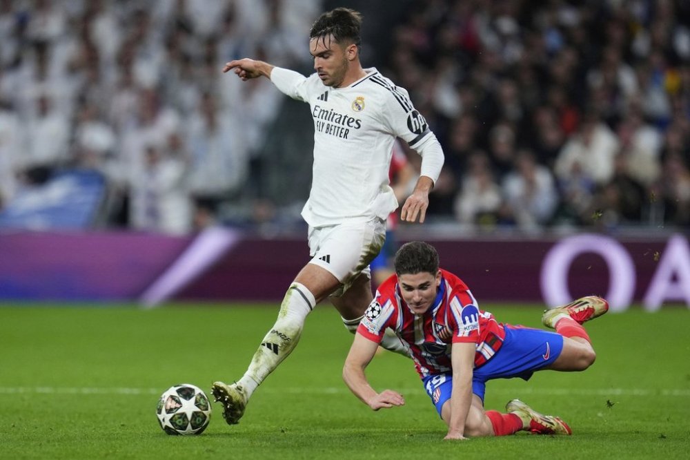 Atletico Madrid's Julian Alvarez, right, is challenged by Real Madrid's Raul Asencio during the Champions League round of 16 first leg soccer match between Real Madrid and Atletico Madrid at the Bernebeu stadium in Madrid, Spain, Tuesday, March 4, 2025. (AP Photo/Manu Fernandez)