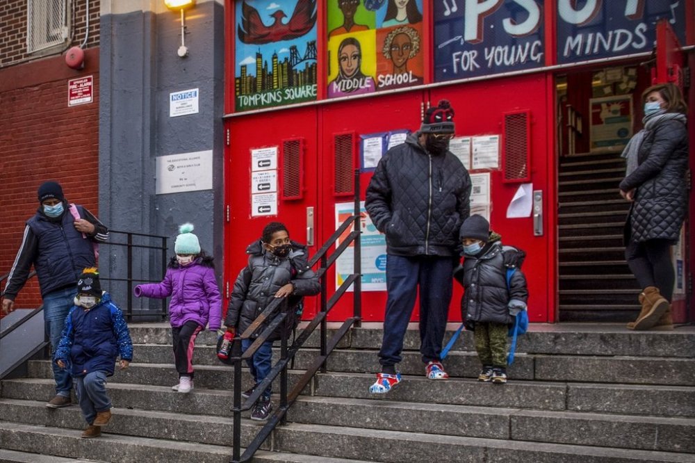 FILE - Children and their guardians leave P.S. 64 in the East Village neighborhood of Manhattan, Tuesday, Dec. 21, 2021, in New York. (AP Photo/Brittainy Newman, File)