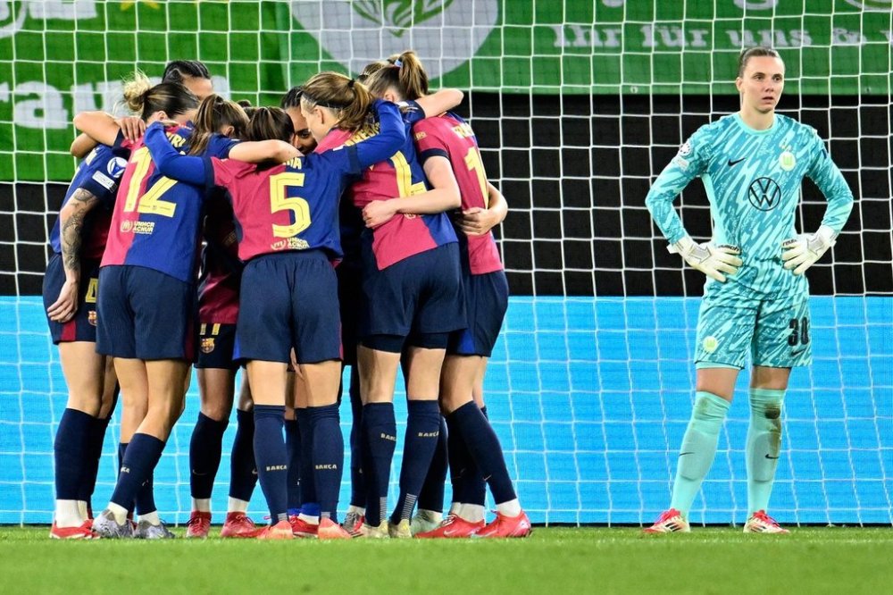 Barcelona's players celebrate their side's third goal during the Women's Champions League, quarter-final first leg, soccer match between VfL Wolfsburg and FC Barcelona in Wolfsburg, Germany, Wednesday, March 19, 2025. (Swen Pfoertner/dpa via AP)