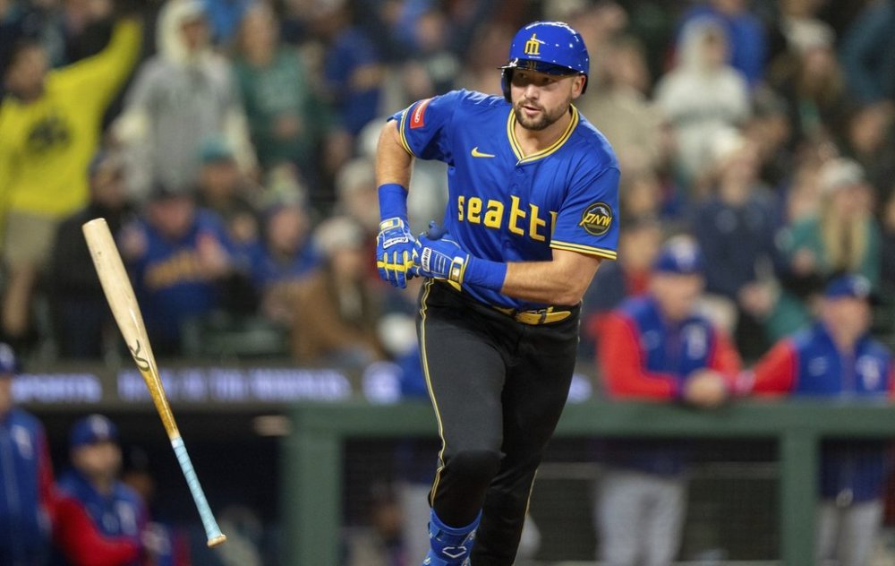 Seattle Mariners' Cal Raleigh tosses his bat after hitting a two-run home run during the eighth inning of a baseball game against the Texas Rangers, Friday, April 11, 2025, in Seattle. (AP Photo/Stephen Brashear)