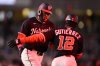 Washington Nationals' James Wood, left, is greeted by third base coach Ricky Gutierrez (12) as he rounds the bases on his two-run home run during the fourth inning of a baseball game against the Los Angeles Dodgers, Tuesday, April 8, 2025, in Washington. (AP Photo/Nick Wass)