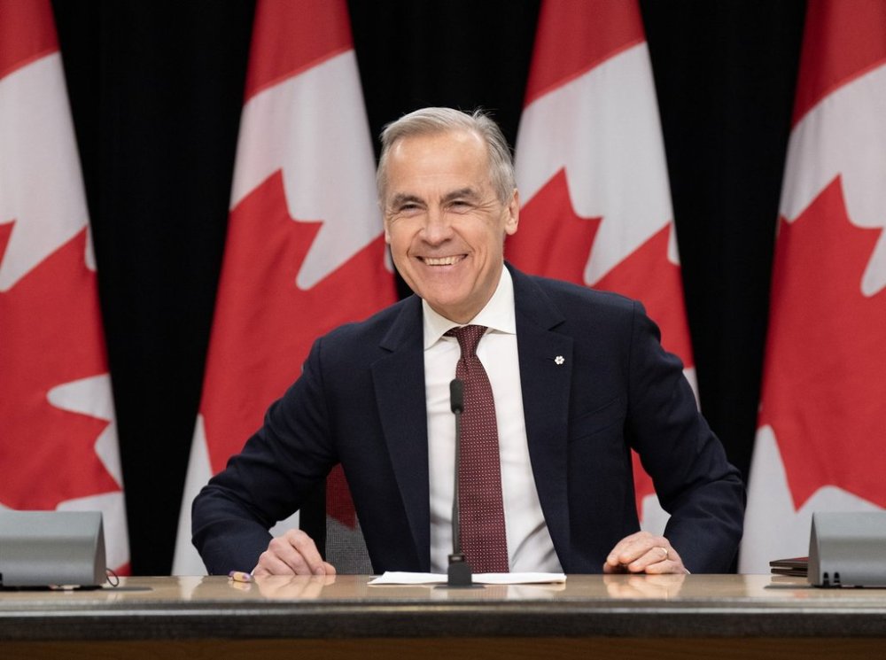 Prime Minister Mark Carney smiles as he takes his seat at his first news conference since winning the federal election, in Ottawa, Friday, May 2, 2025. THE CANADIAN PRESS/Adrian Wyld