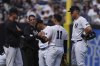 New York Yankees' Aaron Judge, right, and manager Aaron Boone, left, watch as a trainer checks on Anthony Volpe during the eighth inning of a baseball game against the Tampa Bay Rays Saturday, May 3, 2025, in New York. (AP Photo/Frank Franklin II)