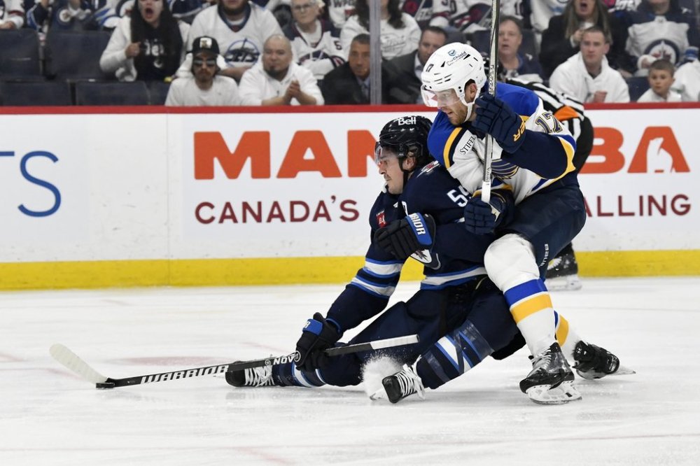 St. Louis Blues defenceman Cam Fowler (17) checks Jets forward Mark Scheifele (55) during second-period NHL playoff action in Winnipeg on Monday, April 21, 2025. THE CANADIAN PRESS/Fred Greenslade