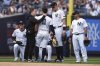 New York Yankees' Trent Grisham, right, and Aaron Judge, second from right watch as a trainer checks on New York Yankees' Anthony Volpe (11) after he was injured during the eighth inning of a baseball game against the Tampa Bay Rays Saturday, May 3, 2025, in New York. (AP Photo/Frank Franklin II)