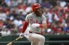 Philadelphia Phillies' Brandon Marsh follows through after hitting a single against Washington Nationals pitcher Mitchell Parker during the seventh inning of a baseball game in Washington, Sunday, March 30, 2025. (AP Photo/Terrance Williams)