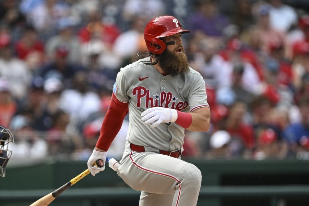 Philadelphia Phillies' Brandon Marsh follows through after hitting a single against Washington Nationals pitcher Mitchell Parker during the seventh inning of a baseball game in Washington, Sunday, March 30, 2025. (AP Photo/Terrance Williams)