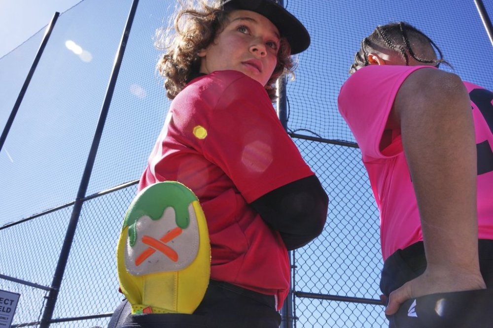 Youth ballplayer Grayson Cole, left, waits for his game to get underway with his Savannah Banana sliding mitt in his back pocket on April 27, 2025 in Monroeville, Pa. (AP Photo/Gene J. Puskar)
