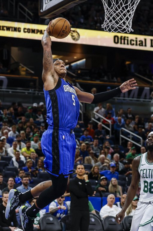Orlando Magic forward Paolo Banchero (5) dunks the ball against the Boston Celtics during the second half of an NBA basketball game, Wednesday, April 9, 2025, in Orlando, Fla. (AP Photo/Kevin Kolczynski)