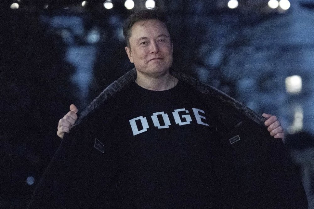 FILE - Elon Musk flashes his T-shirt that reads