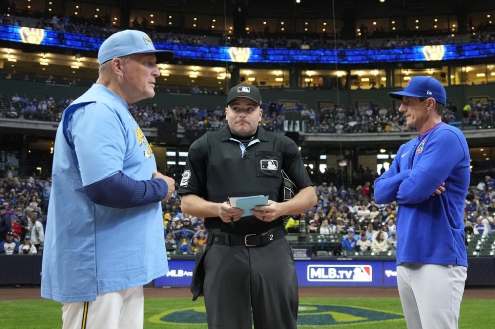 Milwaukee Brewers manager Pat Murphy, left, and Chicago Cubs manager Craig Counsell, right, exchange lineups with umpire Jansen Visconti, center, before a baseball game Friday, May 2, 2025, in Milwaukee. (AP Photo/Kayla Wolf)
