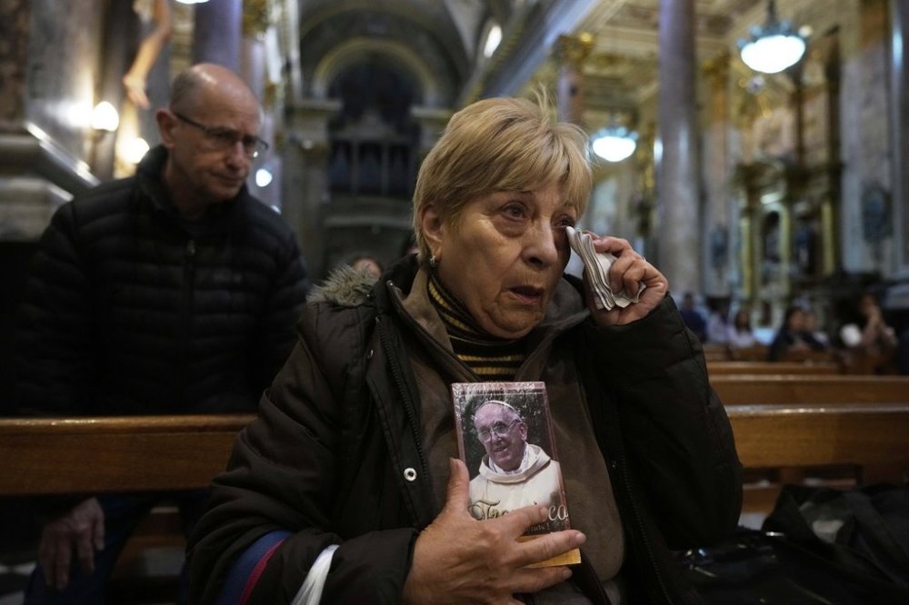 Maria Teresa Delgado holds a portrait of the late Pope Francis during Mass at the Basílica de San José de Flores, where he worshipped as a youth, following the Vatican's announcement of his death in Buenos Aires, Argentina, Monday, April 21, 2025. (AP Photo/Gustavo Garello)