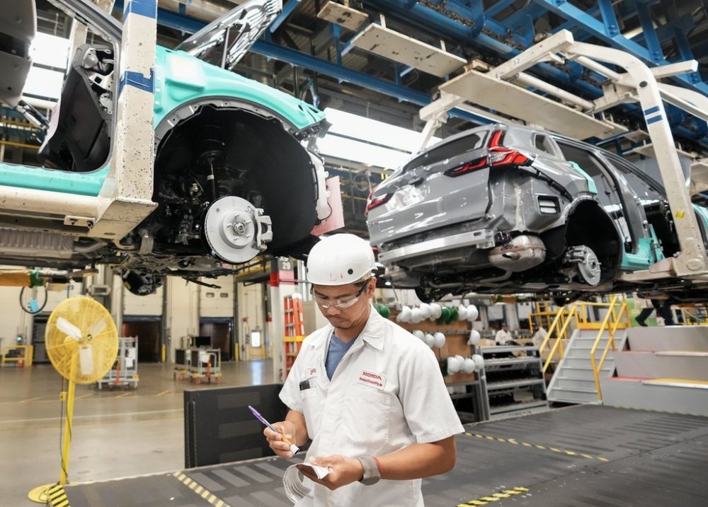 Honda employees work along the vehicle assembly line before an event announcing plans for a Honda electric vehicle battery plant in Alliston, Ont., on Thursday, April 25, 2024. THE CANADIAN PRESS/Nathan Denette