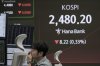A currency trader watches monitors near a screen showing the Korea Composite Stock Price Index (KOSPI) at the foreign exchange dealing room of the KEB Hana Bank headquarters in Seoul, South Korea, Tuesday, April 22, 2025. (AP Photo/Ahn Young-joon)