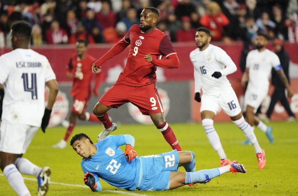 Canada's Cyle Larin (9) watches the ball sail into the net as he scores on Panama goalkeeper Orlando Mosquera (22) during first half men's international friendly soccer action in Toronto, on Tuesday, October 15, 2024. THE CANADIAN PRESS/Frank Gunn