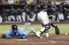 Tampa Bay Rays' Danny Jansen, left, scores a run as Arizona Diamondbacks catcher Jose Herrera, right, reaches for the ball on a late throw during the seventh inning of a baseball game Wednesday, April 23, 2025, in Phoenix. (AP Photo/Ross D. Franklin)