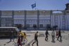 FILE - Palestinians walk next to the closed humanitarian aid distribution center of UNRWA, the U.N. agency helping Palestinian refugees in Jabaliya, Gaza Strip on Tuesday, April 29, 2025. (AP Photo/Jehad Alshrafi, File)