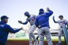 Los Angeles Dodgers Teoscar Hernández (37) is greeted at the dugout after he hit a two run home run driving in Dodgers Tommy Edman, right, during the first inning of a baseball game against the Washington Nationals Wednesday, April 9, 2025, in Washington. (AP Photo/John McDonnell)