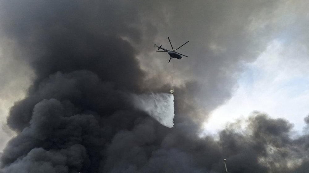 A helicopter drops water on the fire, Sunday, April 27, 2025, after a massive explosion and fire rocked a port near the southern port city of Bandar Abbas, Iran on Saturday. (AP Photo/Meysam Mirzadeh/Tasnim News)