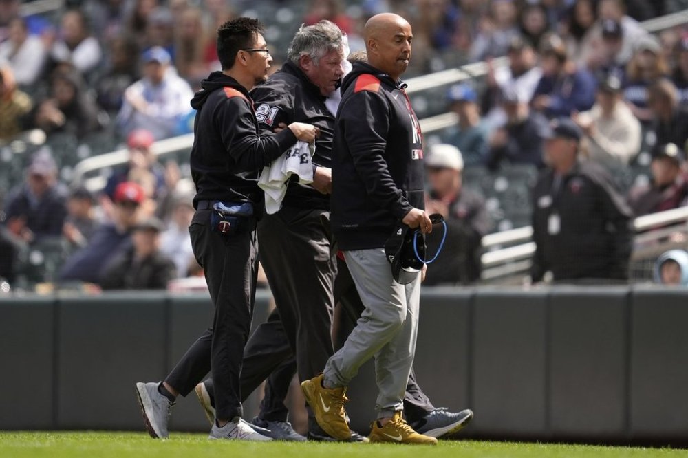 First base umpire Hunter Wendelstedt, center, walks off the field with medical staff after being hit by a foul ball during the seventh inning of a baseball game between the Minnesota Twins and New York Mets, Wednesday, April 16, 2025, in Minneapolis. (AP Photo/Abbie Parr)