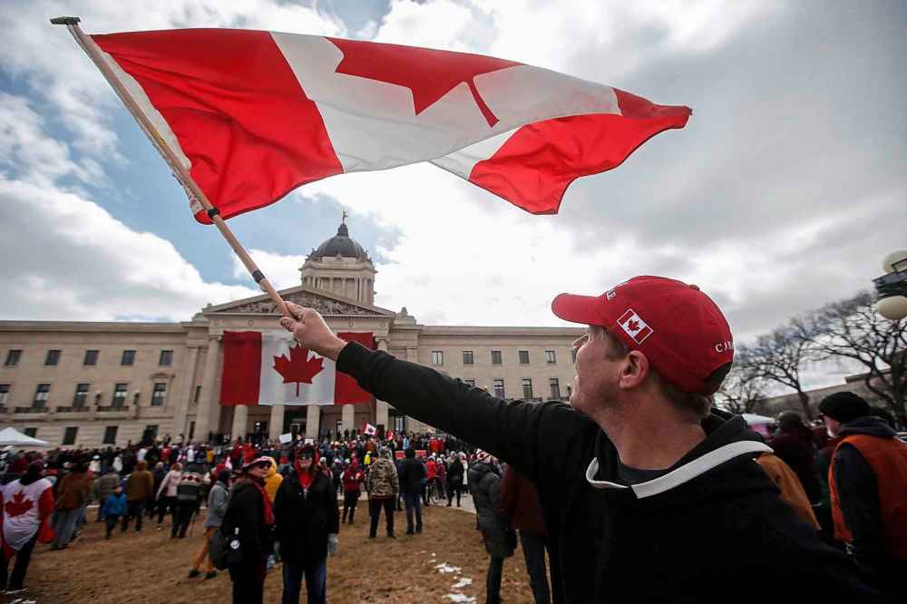 Adam Hannah waved his flag at the legislative grounds for the Rally For Canada event, Sunday, April 6, 2025. (John Woods / Free Press)