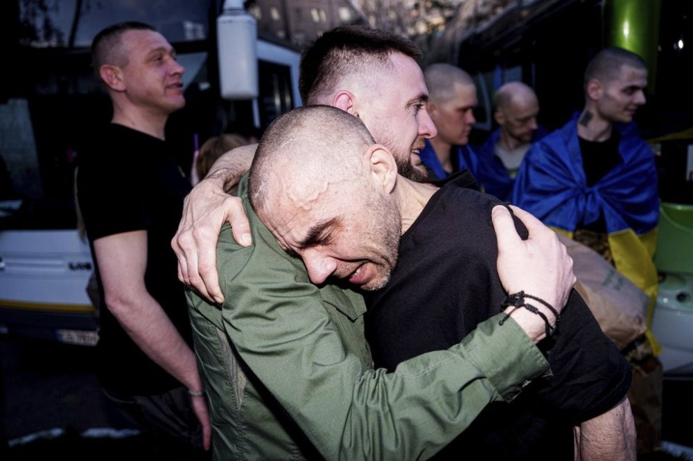A Ukrainian soldier hugs his comrade after returning from captivity in a POW exchange in Ukraine, on Saturday, April. 19, 2025. (AP Photo/Evgeniy Maloletka)