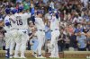 Chicago Cubs' Ian Happ, right, high-fives Nico Hoerner after hitting a grand slam during the seventh inning of a baseball game against the Arizona Diamondbacks, Friday, April 18, 2025, in Chicago. (AP Photo/Erin Hooley)