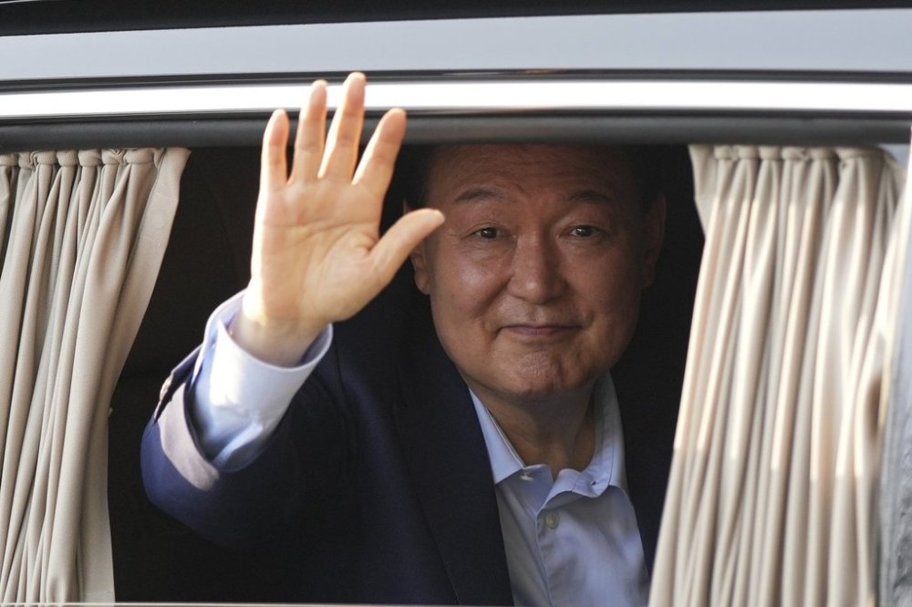 Former South Korean President Yoon Suk Yeol waves upon his arrival at the private residence in Seoul, South Korea, Friday, April 11, 2025. (AP Photo/Lee Jin-man)