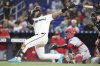Miami Marlins' Agustin Ramirez, left, follows through on a RBI double to score Eric Wagaman during the sixth inning of a baseball game against the Cincinnati Reds, Tuesday, April 22, 2025, in Miami. (AP Photo/Lynne Sladky)