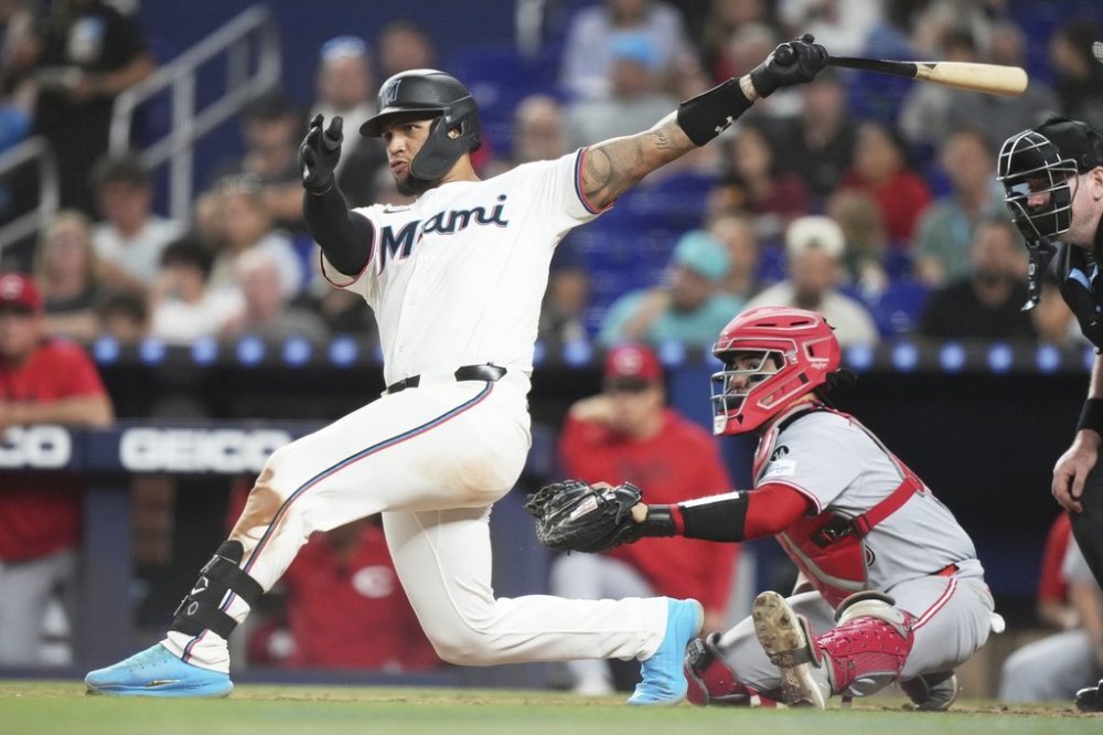 Miami Marlins' Agustin Ramirez, left, follows through on a RBI double to score Eric Wagaman during the sixth inning of a baseball game against the Cincinnati Reds, Tuesday, April 22, 2025, in Miami. (AP Photo/Lynne Sladky)