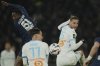 Marseille's Adrien Rabiot, right, jumps for the ball with PSG's Willian Pacho during the French League One soccer match between Paris Saint Germain and Marseille at Parc des Princes stadium in Paris, Sunday, March 16, 2025. (AP Photo/Christophe Ena)