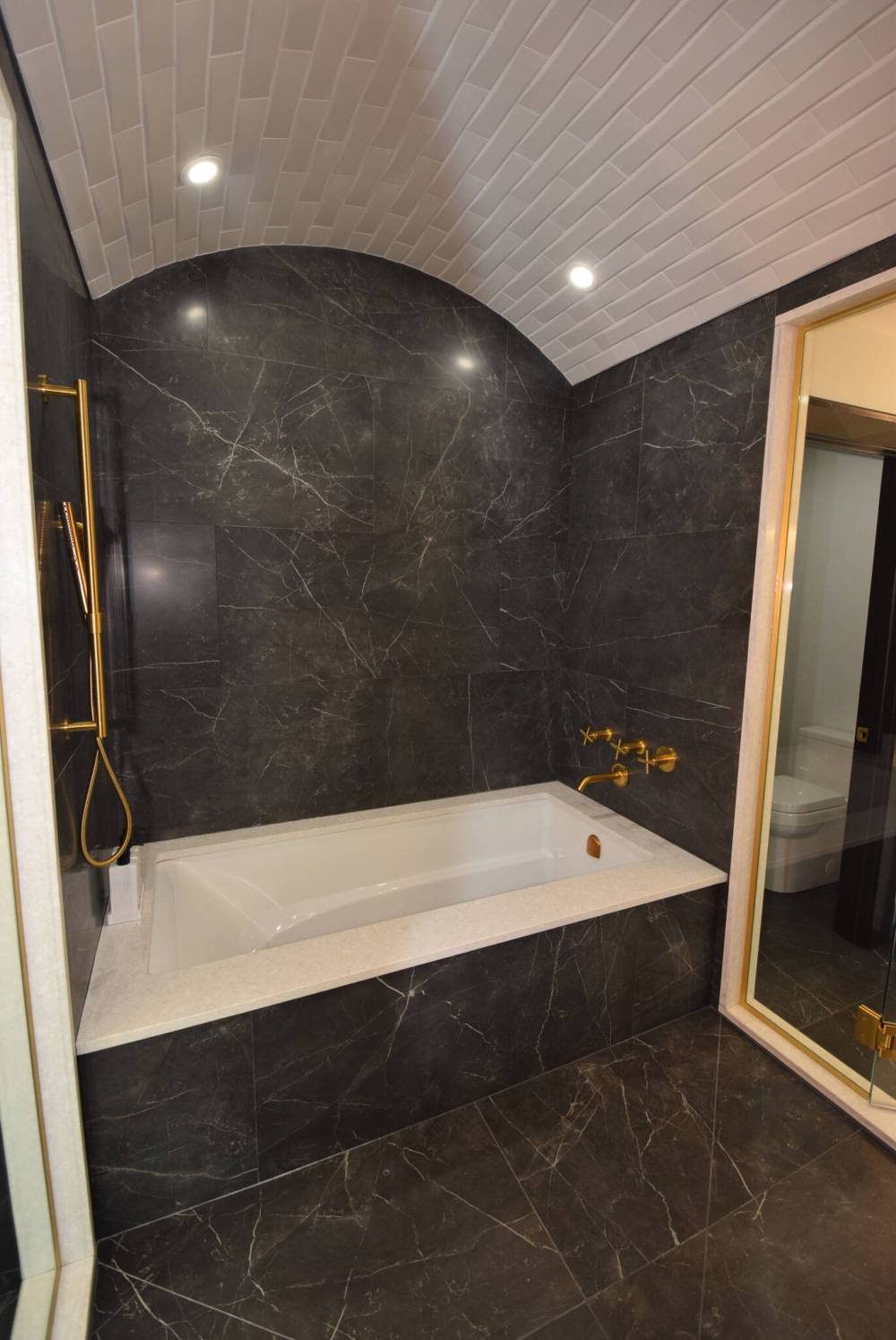 TODD LEWYS / FREE PRESS
A deep soaker tub surrounded by charcoal-toned tile and a grey barrel ceiling overhead is just part of the primary bedroom’s ensuite, which also features with a stunning shower area.