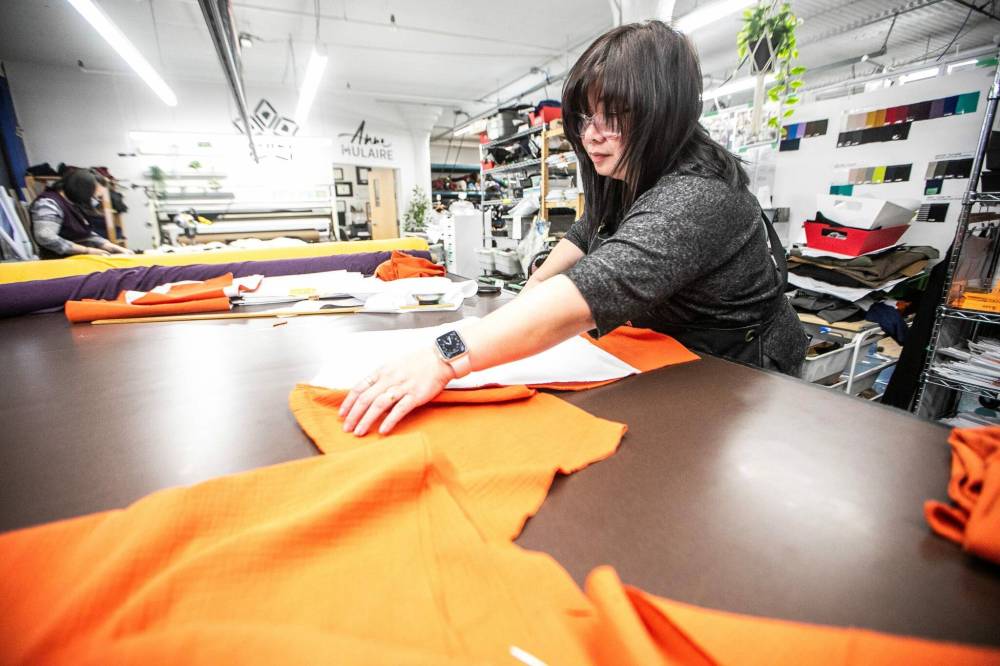 MIKAELA MACKENZIE / FREE PRESS
Anne Mulaire production supervisor Veronica Arida (top) cuts fabric in